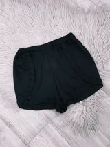 Short negro con cintura elástica y volados en los laterales y en el ruedo.