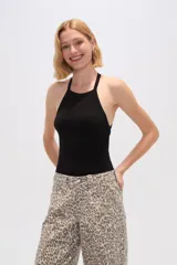 Body de tejido acanalado con cuello halter y espalda descubierta, confeccionado en poliéster con cierre de broches en la parte inferior.