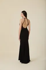 Vestido largo negro de gala con escote profundo y detalles de encaje bordado en el torso. Presenta breteles finos y una falda de corte recto con caída fluida.