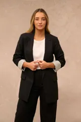 Blazer Atina de color negro con solapas clásicas, bolsillos con solapa en la parte frontal y mangas largas con vuelta estampada a rayas.