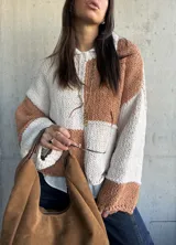 Sweater de punto con diseño de bloques de color en tonos camel y crudo, de corte holgado, cuello redondo y mangas largas con puños anchos.