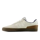 Championes New Balance Numeric 272, diseñados para skate, con parte superior de gamuza y materiales sintéticos en color beige. Presentan suela de goma color marrón, detalles en azul marino y el logo N característico en el lateral.