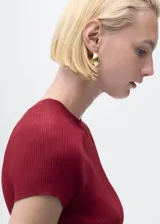 Jersey de punto fino de canalé color bordó, con cuello redondo y mangas cortas de corte recto.