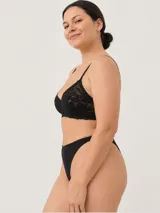 Soutien negro confeccionado en encaje con diseño floral, tirantes finos regulables y cierre posterior.