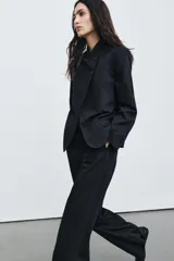 Pantalón de tiro alto con diseño de raya diplomática, corte recto y raya planchada en el delantero. Cuenta con cintura con trabillas, bolsillos laterales y bolsillos de vivo en la parte trasera. Cierre frontal con cremallera, botón y ganchos metálicos.