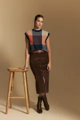 Falda midi de pana color marrón, con tiro alto, abotonadura frontal completa y bolsillos aplicados en el frente.