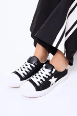 Championes de lona color negro con puntera y cordones blancos, presentan un detalle de estrella blanca en el lateral.