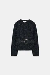 Blazer de cuello redondo y manga larga, confeccionado en tejido de tweed con textura. Presenta un diseño entallado con cinturón forrado a tono con hebilla metálica y cierre frontal mediante botones a presión ocultos.