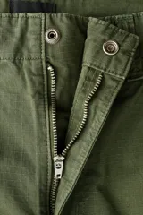 Pantalón de corte relajado confeccionado en tejido ripstop, con cierre de botón a presión, bolsillos al bies y bolsillos traseros de parche. Presenta costuras horizontales en las piernas y cordón ajustable en los bajos.