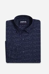 Camisa de hombre de manga larga con look lino, confeccionada en algodón. Presenta un estampado integral de hojas en tonos azul, beige y terracota, con cierre frontal abotonado y logo bordado en el pecho.