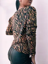 Remera de manga larga con cuello redondo y estampado de cebra en colores verde, rojo, azul y marrón.