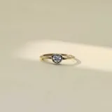 Anillo fino de plata y oro con un dije central en forma de corazón engastado con una circonia brillante.