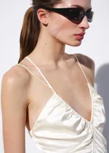 Vestido corto satinado de color beige, con diseño entallado, fruncidos ajustables laterales, escote de pico y tirantes finos.