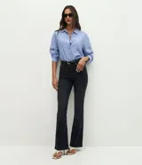 Pantalón de jean corte bootcut, color negro, con tiro alto, trabillas en la cintura, cierre de botón y bolsillo reloj.