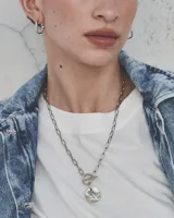 Aros de diseño minimalista con forma de argolla pequeña, realizados artesanalmente en bronce y alpaca con pernos de plata 925.