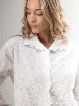 Camisa blanca de manga larga con bordado de encaje en el frente y mangas semi abullonadas.