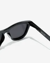 Lentes de sol unisex Hawkers modelo One Venm Raw, con montura cuadrada negra y lentes polarizadas negras.