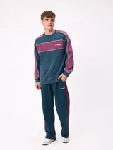 Pantalón tipo babucha de la marca Rusty, color azul petróleo con franjas laterales en color bordó. Presenta cintura elástica con cordón ajustable y logo bordado en la pierna izquierda.