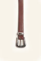 Cinto de cuero color marrón con hebilla metálica plateada estilo tejano.