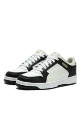 Championes deportivos Puma en color blanco y negro, con detalles en dorado y cordones blancos.