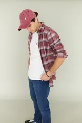 Camisa leñadora de algodón peinado a cuadros en tonos bordó, con cuello italiano y mangas largas.