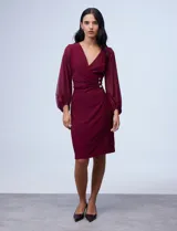 Vestido midi color borgoña, con escote en V cruzado, mangas largas abullonadas de gasa y cintura drapeada con aplique de botones.