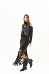 Pollera midi de cuerina negra con diseño ajustado en la parte superior y terminación en flecos largos que aportan movimiento.