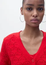 Cardigan de punto fino color rojo con diseño calado de crochet, escote en V y cierre frontal con botones.