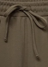 Pantalon de corte recto y estilo jogger, color verde militar, con cintura elástica, lazo ajustable y costuras decorativas frontales.