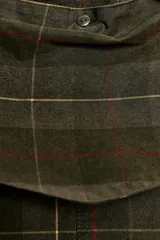 Chaqueta encerada de algodón 100% con estampado de cuadros en tonos verde militar, beige y rojo. Presenta cuello solapa, mangas largas con diseño de capa, bolsillos de plastrón con solapa en el delantero y cierre frontal con botones a presión dorados. Incluye un pañuelo desmontable del mismo tejido.