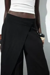 Pantalón de tiro medio color marrón, con pierna recta y detalle de superposición frontal tipo pareo.