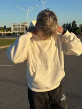 Hoodie de color blanco off-white con diseño de capucha, bolsillo frontal tipo canguro y bordado en relieve con el texto ITTAI STARS y un logo caligráfico.