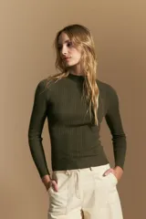 Polera de punto acanalado color gris, con cuello alto y mangas largas, de calce ajustado al cuerpo.