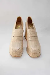 Mocasines color beige con estampado de piel de cocodrilo, plataforma y tacón cuadrado.