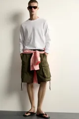 Camiseta de manga larga con cuello redondo y corte relajado. Presenta un pequeño bolsillo tipo plastrón con solapa en la manga izquierda.