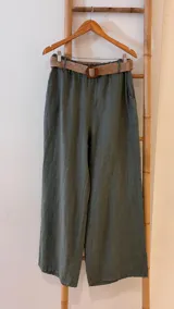 Pantalón verde militar de lino, corte ancho, con cintura elastizada y cinturón de raffia extraíble.