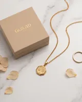 Dije de acero con baño de oro en forma octogonal, con grabado central del árbol de la vida.