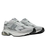 Championes New Balance modelo 2010, color gris. Presentan una capellada que combina malla transpirable con superposiciones de nobuk y materiales sintéticos. Cuentan con entresuela con tecnología ABZORB para absorción de impactos, inserciones SBS en talón y antepié, y refuerzo TPU Stability Web en la zona media para mayor estabilidad.