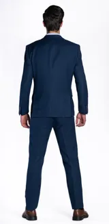 Ambo de vestir para hombre en color azul marino, compuesto por saco de botonadura simple con solapas de muesca, bolsillos con solapa y pañuelo decorativo en el bolsillo superior, acompañado de pantalón de corte recto y formal.