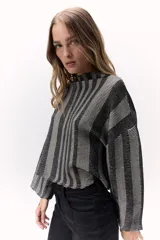 Sweater tejido de punto a rayas horizontales texturizado con lurex, color gris y negro. Cuenta con un calce oversize, mangas tres cuartos y cuello bote.