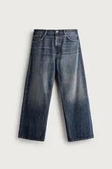 Jeans de denim de algodón en color azul con efecto desgastado, tiro medio y corte recto de ajuste holgado (loose fit). Cuenta con diseño clásico de cinco bolsillos y cierre frontal con cremallera y botón.
