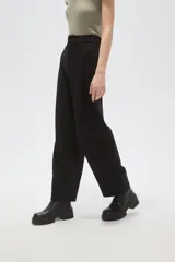 Pantalon de vestir de corte barrel y tiro alto, color negro, con cierre frontal y bolsillos laterales.