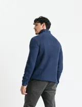 Sweater de punto inglés color verde, con cuello alto y cierre frontal parcial metálico. Diseño de manga larga con puños y ruedo acanalados.