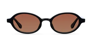 Lentes de sol con montura ovalada de acetato negro y lentes color marrón. Presentan un detalle en la parte superior de las patillas en color blanco.