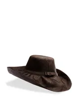 Sombrero marrón de paja con forma de sombrero vaquero y cinta decorativa con moño.