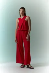 Mono rojo con cuello halter, corte holgado y pierna ancha.