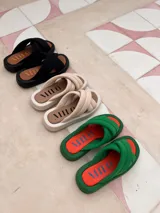 Sandalias de plataforma con diseño de tiras cruzadas acolchadas en color verde y plantilla en color naranja.