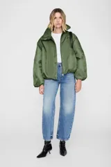 Chaqueta de estilo bomber en color verde oliva, con calce oversize y relajado. Presenta cuello alto tipo funnel, cierre frontal oculto con cremallera, mangas dolman y puños con frunces. Incluye bolsillos laterales integrados y forro interior al tono.
