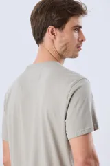 Remera Legacy de manga corta y cuello redondo, color azul melange, con estampa frontal y detalles bordados de un vehículo todoterreno acompañados por el texto "The Adventure Club".