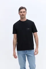Remera de algodón color negro, con cuello redondo, mangas cortas y bolsillo frontal con logo estampado.